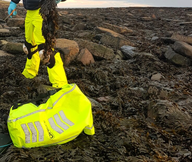 Emergency bag with safety equipment on shore during seaweed harvest