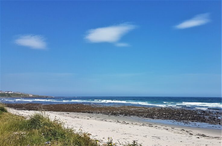 Sandy beach and rocky shore by Keiss in Caithness on a sunny day